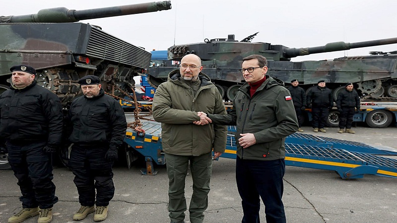 الرئيس البولندي ماتيوز مورافيكي (يمين) يسلم أول دبابة قتال رئيسية من طراز Leopard 2A4 في كييف