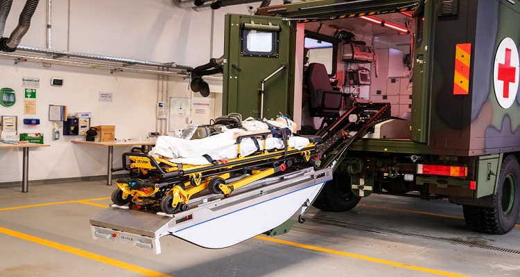 يتم نقل المرضى إلى سيارة نقل الجرحى مع نقالات M1 Roll-In وتخزينها بأمان